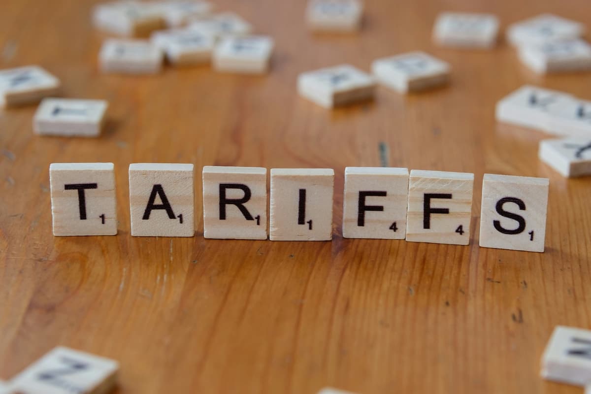 The word 'TARIFFS' spelled out with wooden letter tiles on a table, illustrating the topic of import duties.